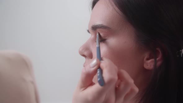 Makeup Artist Applying Purple Eyeshadow on Female Eyes