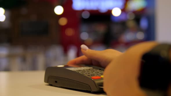 Customer Makes Credit Card Payment Over Counter at a Cafe