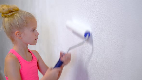 Blonde Girl Making Repairs at Home Painting Paint Roller Wall White Paint