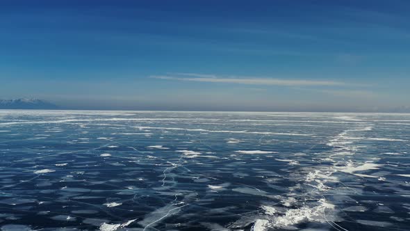 Aerial Perspective View of Beautiful Deep Blue Ice Textured Frozen Baikal Lake Surface From Above