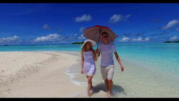 Two lovers tanning on paradise bay beach time by blue sea and clean sand background of the Maldives 