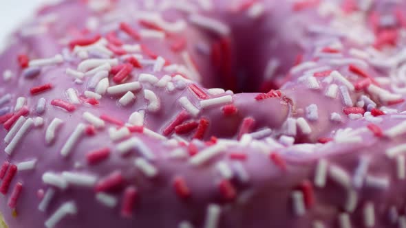 Close-up of an appetizing fresh sweet donut covered with pink icing