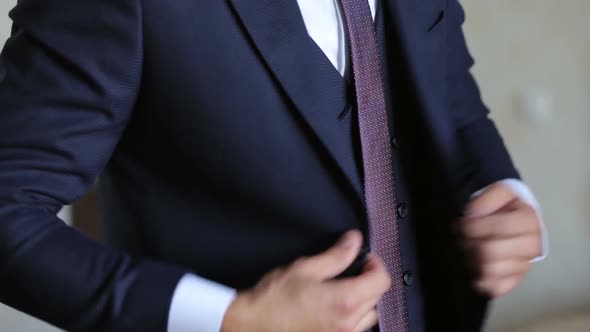 A Successful Young Man Puts on a Suit Jacket in the Morning.