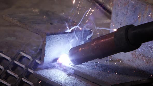 Close view of arc welder sparking as sparks shoot around. alt