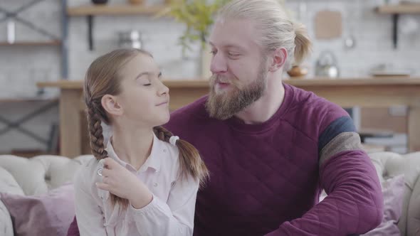 Portrait of Caucasian Man and Teenage Girl Looking at Each Other, Turning To Camera and Smiling