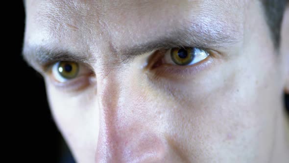 Close-up of the Eyes and Face of a Young Man Working at a Computer on a Black Background