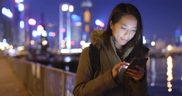 Woman using smart phone at night