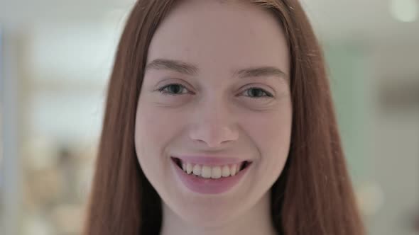 Close Up of Cheerful Young Woman Smiling at Camera