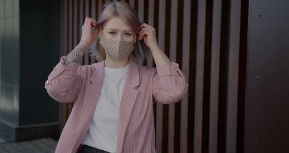 Portrait of Beautiful Young Blonde Putting on Reusable Mask Indoors at Home
