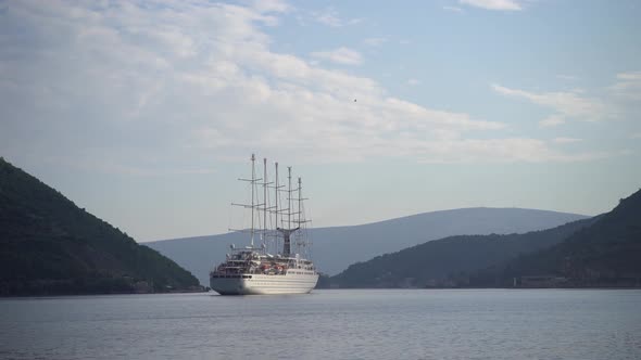 Large Sailboat Floats on the Kotor Bay Against the Backdrop of Mountains