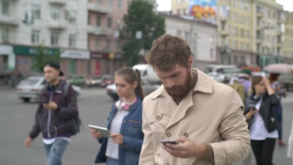 Young People with Gadgets Crossing Street