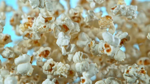 Super Slow Motion Shot of Popcorn on Blue Background After Being Exploded at 1000Fps.