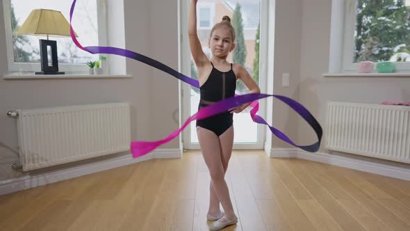 Live Camera Zoom Out As Concentrated Talented Teen Gymnast Twirling Gymnastic Ribbon in Slow Motion