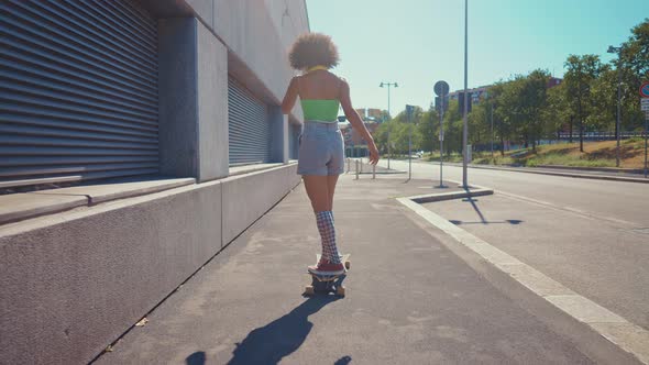 Beautiful young woman cruising around the city with her longboard.