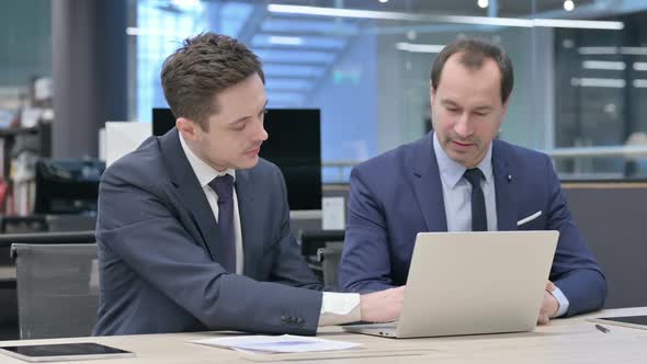 Businessman and Colleague Discussing on Laptop