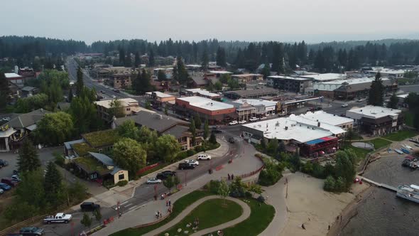 Counterclockwise drone shot of cars coming into the lakeside town of McCall, Idaho during sunset. Th
