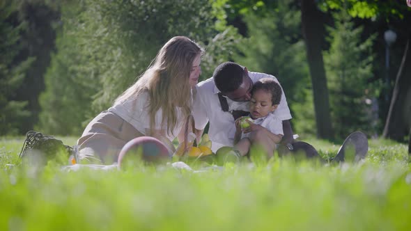 Black Father Fairskinned Mother and Mestizo Child in the Park