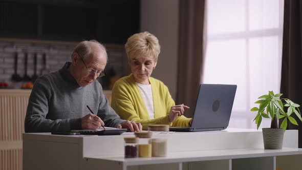 Housekeeping and Calculating Family Budget Retirees Married Couple is Counting Together at Home