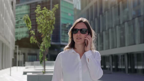 businesswoman talking on cellphone with walking city street.  