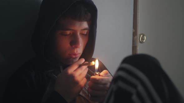 Teen Boy Lights And Smokes Marijuana Joint Or Cigarette