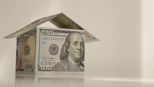 Tilting on dollar house on white background 4K 2160p 30fps UltraHD footage - USD paper currency made