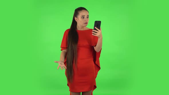 Pretty Young Woman Is Angrily Talking for Video Chat Using Mobile Phone. Green Screen