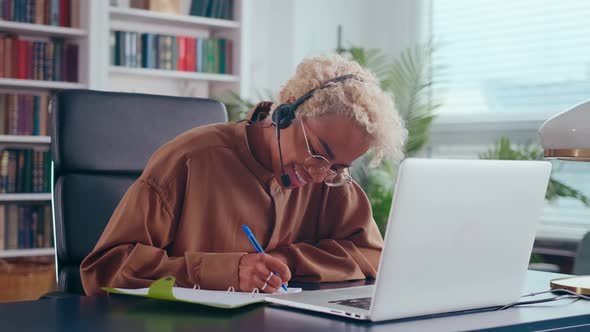 Young Happy African American Woman Student Using Headset Sits Front Laptop