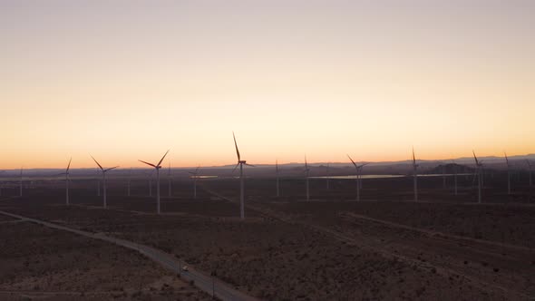 Car Driving down desert road next to windmills, mojave desert, mojave california