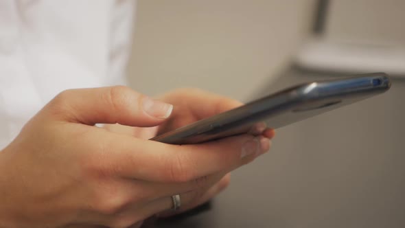 Cute Girl Uses Smartphone at Work