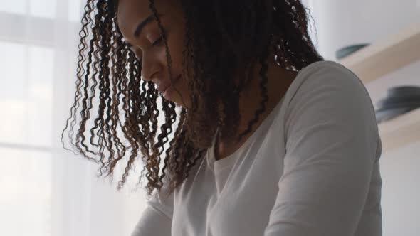 Close Up Below Portrait of Focused African American Woman Doing Something at Home Kneading Dough or