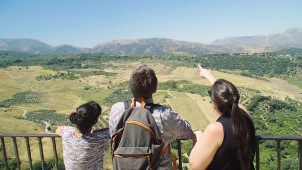 Tourist friends on balcony vista point out Serrania de Ronda landscape, Spain