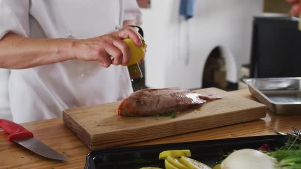 Caucasian female chef preparing a dish and smiling in a kitchen