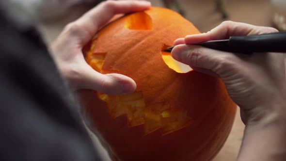 Footage of a person carving out the teeth of a Halloween pumpkin