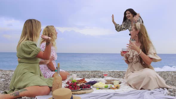 A Friend of Three Women Joins a Picnic By the Sea