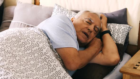 Senior man yawning on bed