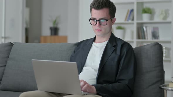 Attractive Young Male Designer with Laptop Smiling at the Camera 