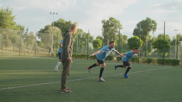 Balance Training of Soccer Players on Bosu Ball with Trainer Outdoors