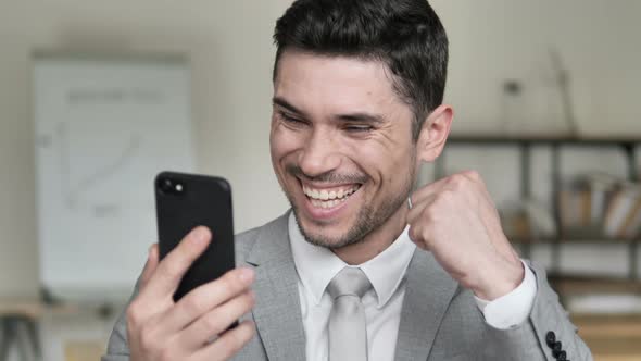 Businessman Excited for Results on Smartphone