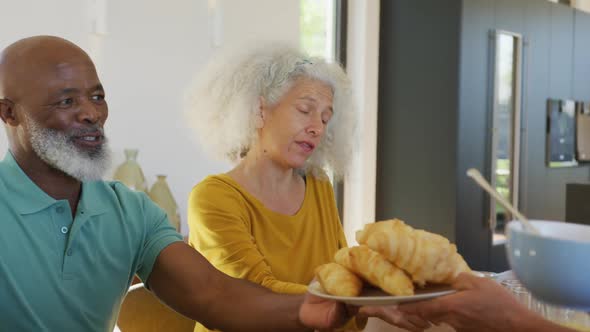 Happy senior diverse people having breakfast at retirement home