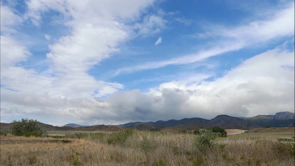 Mountains Against the Blue Sky with White Clouds. Cirrus Clouds Run Across the Blue Sky