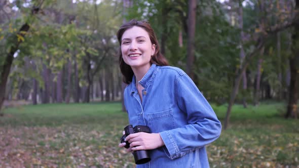 Portrait of a Professional Freelancer with a Camera in Hand in the Autumn Forest at Sunset