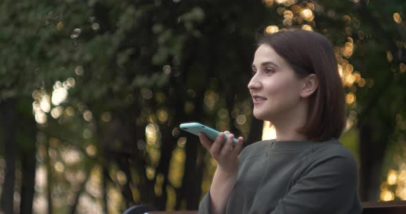 Happy Girl Using a Smart Phone Voice Recognition Audio Message Function on Line Walking on a Street