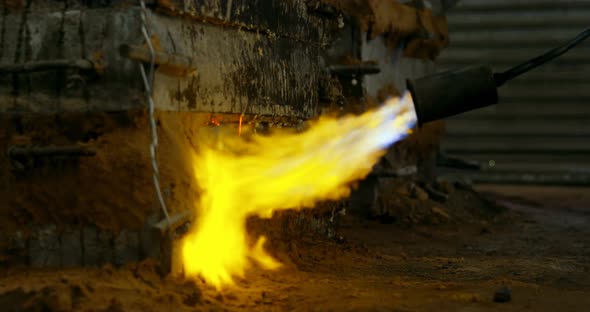 Close-up of metal mold heating with blow torch in foundry workshop 4k