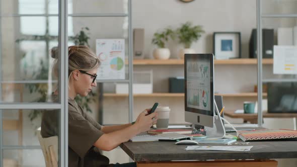 Businesswoman Using Smartphone at Workplace in Office