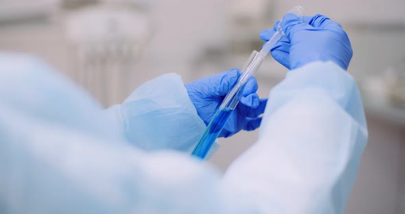 Portrait of Female Scientist Analyzing with a Pipette at Laboratory