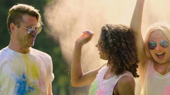 Smiling Young People Covered in Holi Colors Throwing Paint Powder, Having Fun