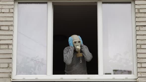 Old Man in Gas Mask Stay at Window Isolated at Home on Quarantine. Coronavirus