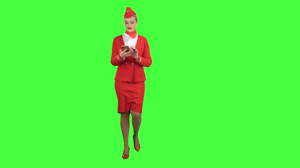 Woman Steps with the Phone and Writes a Message . Green Screen
