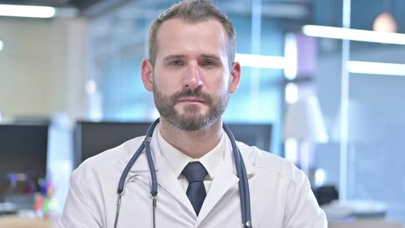 Portrait of Serious Young Doctor Looking at Camera
