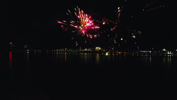 Bright Fireworks Exploding in the Air at Night Near the River